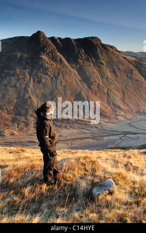 Walker sur Mickleden Bowfell donnant sur la vallée et les Langdale Pikes sur une claire frosty matin dans le Lake District Banque D'Images