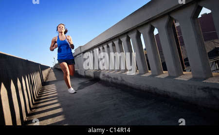 Une jeune fille court sur le trottoir d'un pont au centre-ville de Birmingham, Alabama. Banque D'Images