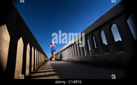 Une jeune fille court sur le trottoir d'un pont au centre-ville de Birmingham, Alabama. Banque D'Images