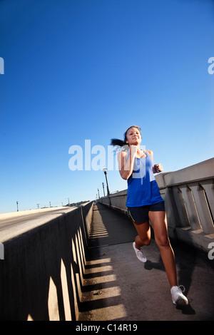 Une jeune fille court en descente sur le trottoir d'un pont au centre-ville de Birmingham, Alabama. Banque D'Images