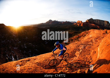 Un homme d'âge moyen chevauche son vtt à travers le red rock country autour de Sedona, Az au coucher du soleil. Banque D'Images