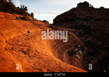 Un homme d'âge moyen chevauche son vtt à travers le red rock country autour de Sedona, Az au coucher du soleil. Banque D'Images