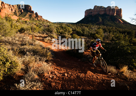 Un homme d'âge moyen chevauche son vtt à travers le pays des roches rouges de Sedona, AZ. Banque D'Images