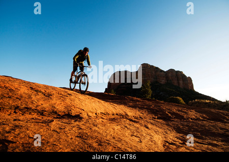 Un homme d'âge moyen chevauche son vélo de montagne à travers le pays des roches rouges de Sedona, AZ. Banque D'Images