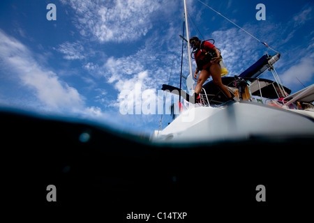 Une jeune femme d'origine hispanique à la vitesse saute sur un catamaran. Banque D'Images
