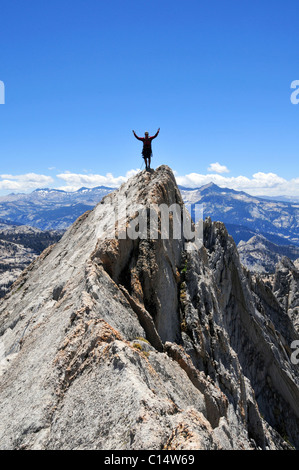 Un alpiniste se tient avec les bras tendus sur Matthes Crest à Yosemite National Park, Californie. Banque D'Images