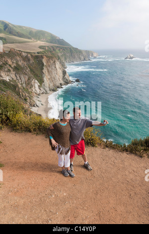 Couple de prendre des photos sur le chemin surplombant les falaises rocheuses/côte de Big Sur, en Californie. Banque D'Images