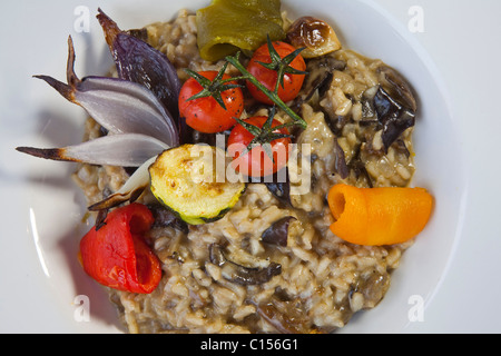 Plat Principal & champignons sauvages séchés 'sun' risotto tomate surmontée d'une salade de roquette et Parmesan sur 'plaque blanche' 11637AA6 Food09 Banque D'Images