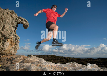 Homme qui court à travers un terrain accidenté dans le parc naturel du Cap de Creus, Catalogne, Espagne Banque D'Images