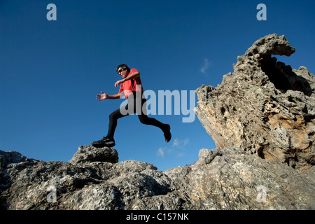 Homme qui court à travers un terrain accidenté dans le parc naturel du Cap de Creus, Catalogne, Espagne Banque D'Images