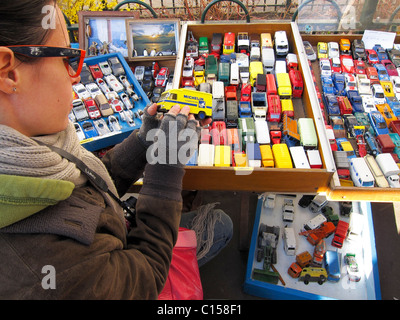 Paris, France, la jeune femme magasiner seule au marché aux puces français, jouets pour enfants, voitures miniatures Banque D'Images