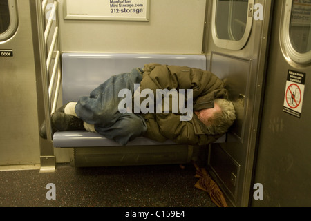 Sans-abri dormir sur un New York City Subway train Banque D'Images