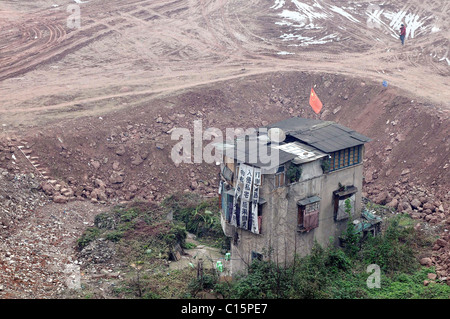 Dernière maison Une maison solitaire permanent est éclipsé par un chantier de construction dans le sud-ouest de la municipalité de Chongqing en Chine. L Banque D'Images