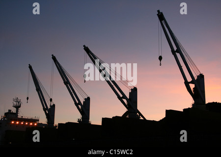 Grues de navire qui se profile au coucher du soleil, Liverpool Docks, UK Banque D'Images