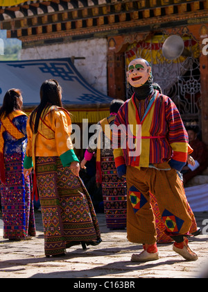 Homme masqué et les femmes dansent sur un tsechus (fesival bhoutanais) Banque D'Images