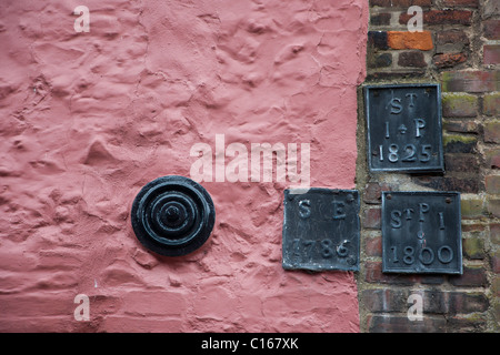 Détail de mur en brique et silex peint en rose avec des oeuvres en fer Banque D'Images