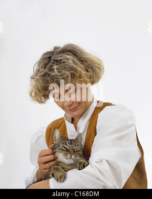 Blond woman holding un chat tigré dans ses bras, le chat est le ronronnement avec jouissance Banque D'Images