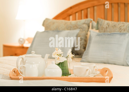 Plateau du petit déjeuner sur un lit dans une chambre de style traditionnel Banque D'Images