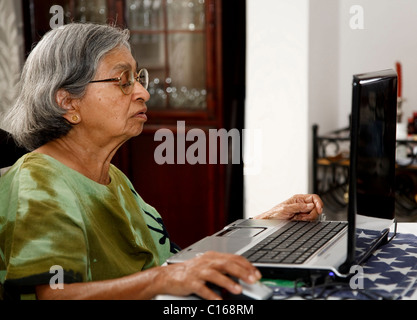 Personnes âgées femme indienne asiatique utilise un ordinateur portable à la maison Banque D'Images