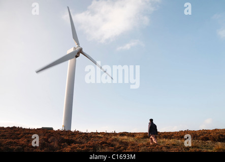 Une femme s'approche d'un randonneur wind farm dans la campagne Banque D'Images