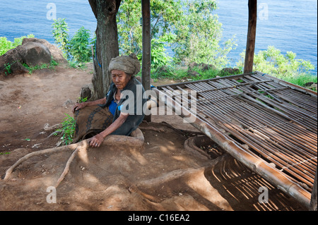 Une vieille dame balinais se trouve à l'ombre dans le village d'Amed, Bali, Indonésie. Banque D'Images