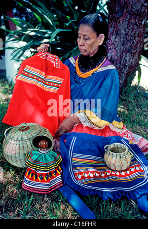 Une vieille femme indienne Miccosukee affiche des vêtements traditionnels et de l'artisanat à son Seminole village tribal dans les Everglades en Floride, USA. Banque D'Images