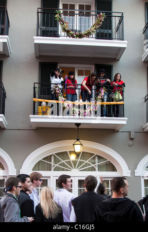 Les femmes sur un balcon flirter et pierres colliers Mardi Gras à foule d'hommes ci-dessous sur Bourbon Street à La Nouvelle Orléans Banque D'Images