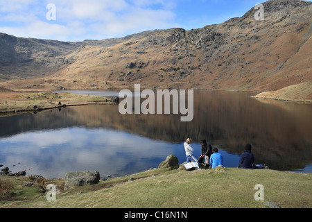 Un groupe de jeunes femmes le repos d'Easdale Tarn en arrière-plan. Lake District Près de Grasmere. Banque D'Images