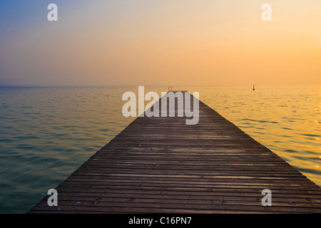 Jetée en bois sur le lac de Garde, au lever du soleil, Sirmione, Lombardie, Italie, Europe Banque D'Images