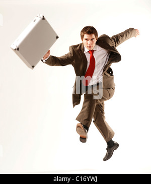 Young businessman carrying a briefcase, sauter en l'air Banque D'Images