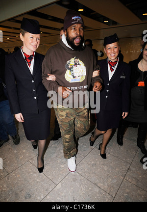 M. Laurence Tureaud T aka aka B. A. Baracus arrive à l'aéroport de Heathrow escorté par deux 'BA' hôtesses. Par l'expression de son Banque D'Images