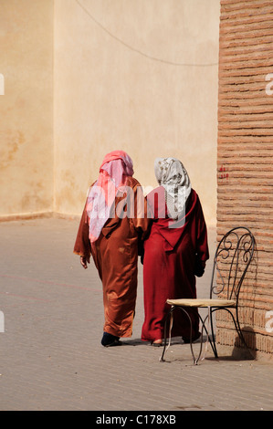 Deux femmes voilées en face de la mosquée Ben Youssef dans la médina de Marrakech, Maroc, Afrique Banque D'Images