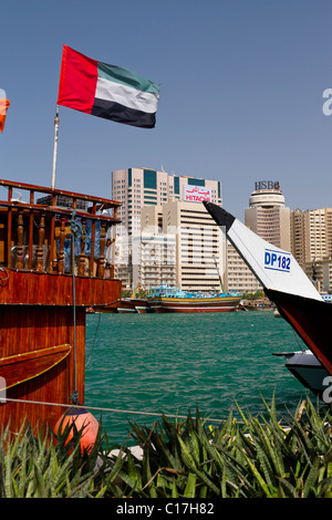 Les EAU drapeau national et restaurant bateaux le long de la Crique de Dubaï à Dubaï, Émirats arabes unis, golfe Persique. Banque D'Images