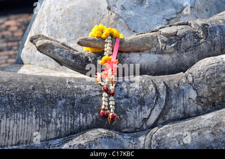 Statue de Bouddha, Bhumispara-mudra, Gautama Bouddha dans l'instant des lumières, Close up of a hand décorées avec des fleurs Banque D'Images