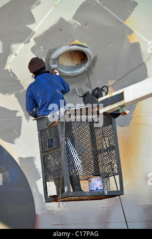 L'application Varnisher peinture anti-rouille, rénovation sur une cale sèche, Cape Town, Afrique du Sud Banque D'Images