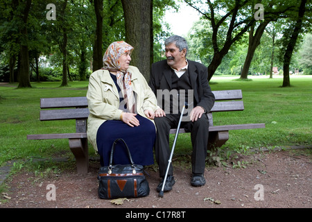 Un vieux couple turc assis sur un banc dans un parc, l'Herne, Allemagne Banque D'Images