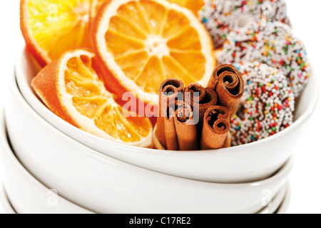 Organge séchés tranches avec cinnammon bâtons et anneaux de chocolat en tas de boules blanches, close-up Banque D'Images