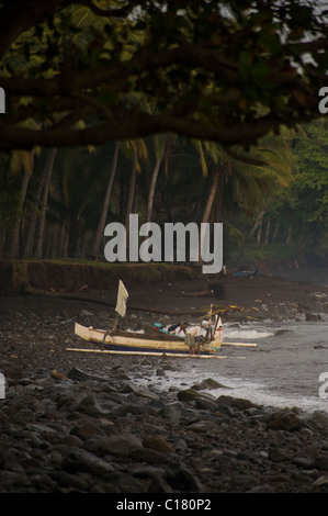 Les pêcheurs balinais tirez sur la plage à Tembok, Bali, après une nuit de la pêche du maquereau dans un outrigger. Banque D'Images