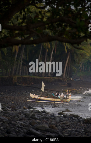 Les pêcheurs balinais tirez sur la plage à Tembok, Bali, après une nuit de la pêche du maquereau dans un outrigger. Banque D'Images