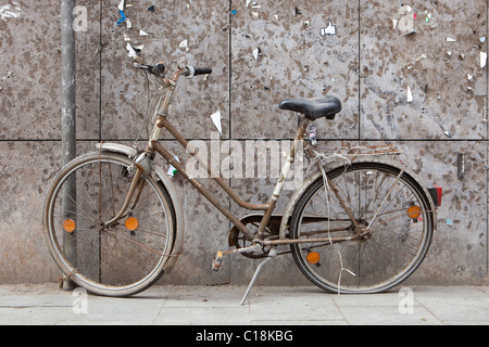 Vieux vélo devant un mur vieilli Banque D'Images