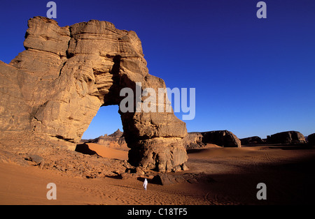 La Libye, la région du désert, le Fezzan (Sahara), Tadrart Akacus, Touareg sous l'arche (en grès) d'Afazedja Banque D'Images