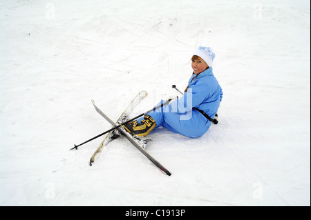 La jeune fille de sportswear sur ski de montagne a diminué et se situe sur la neige, la ville de Domodedovo, dans la région de Moscou, Russie Banque D'Images