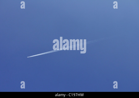 Avion avec traînée de vapeur dans le ciel bleu Banque D'Images