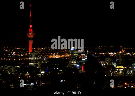 Un couple embrasser tout en regardant les toits de la ville de Auckland au sommet du Mont Eden, le plus haut point naturel à Auckland. Banque D'Images