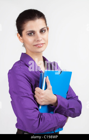 Jeune et jolie brunette woman holding folders plastique en couleur Banque D'Images