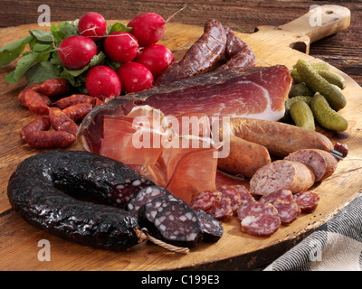 Assiette froide, plateau en bois avec jambon tyrolien, farmer's boudin, saucisse de foie, kaminwurz fumé, radis et cornichons Banque D'Images