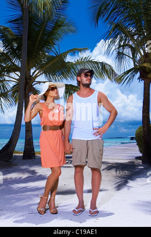 Romantic couple standing next to palm tree Banque D'Images