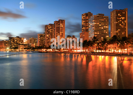 Plage, de la jetée et de complexes hôteliers à Waikiki au crépuscule, O'ahu, Hawaii, USA Banque D'Images