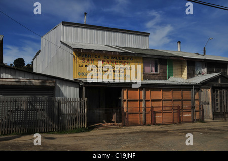 Ciel bleu vue d'une petite en bois marron argent métal-clad usine de fabrication de meubles sur mesure, Ancud, Ile de Chiloé, Chili Banque D'Images