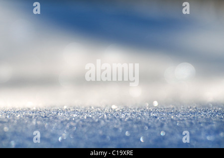 Mousseux blanc-bleu fond de la neige avec des taches de lumière. Il est retiré sur soft focus. Banque D'Images